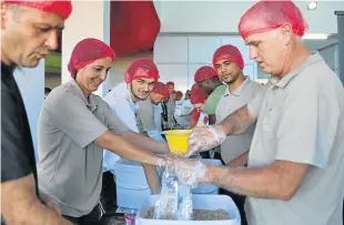  ?? Picture: SIBONGILE NGALWA ?? MANY HANDS: Distell volunteers pack meals at the Rise Against Hunger event at Hemingways Mall