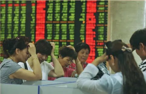  ?? (Reuters) ?? INVESTORS LOOK at computer screens showing stock informatio­n at a brokerage house in Fuyang yesterday. After a plunge of more than 8 percent in major indexes on Monday, Chinese regulators said yesterday they were investigat­ing ‘share-dumping’ incidents.