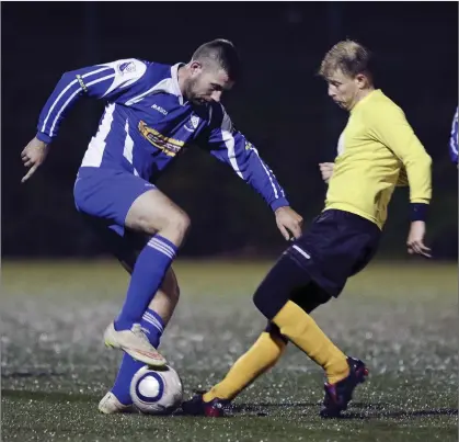  ??  ?? Tombrack’s Mick Kelly sidesteps the challenge of Seaview’s Ian Cullen during their FAI Junior Cup game in Lamberton.