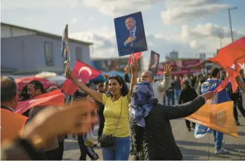  ?? FRANCISCO SECO/AP ?? Supporters of Turkish President Recep Tayyip Erdogan dance last week as they give handouts to commuters in Istanbul. Erdogan’s fate will be decided Sunday when voters in Turkey head back to the polls for a runoff election.