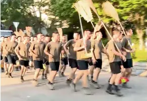 ?? AP ?? In this image from video, People’s Liberation Army soldiers, with brooms, arrive to clean up the protest area at Hong Kong Baptist University.
