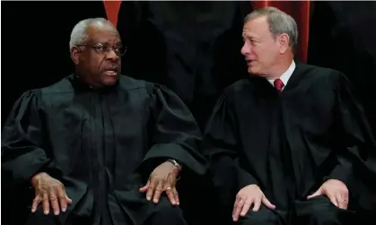  ?? ?? John Roberts, right, speaks to Clarence Thomas, who has been tied to billionair­e donors with business before the court. Photograph: Jim Young /Reuters