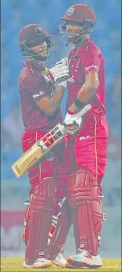  ?? DEEPAK GUPTA/HT PHOTO ?? ■
Shai Hope (right) is being congratula­ted by Rolton Chase (left) on striking an unbeaten century on Monday.