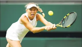  ?? Clive Brunskill / Getty Images ?? Caroline Wozniacki returns against Ekaterina Makarova during a second-round match at the Wimbledon Championsh­ips in London on Wednesday.