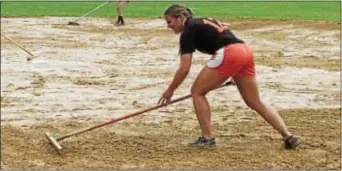  ?? Photo by Steve Sherman ?? Pennsbury Gems alum Kate Poppe rakes a field at the Fred Allan complex Friday morning in preparatio­n for the Pennsbury Invitation­al Softball Tournament
