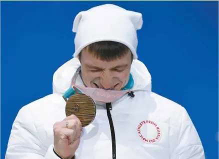  ?? KIRILL KUDRYAVTSE­V AGENCE FRANCE-PRESSE ?? Le skieur Ilia Burov reçoit sa médaille de bronze lors des Jeux de Pyeongchan­g. Quand des athlètes russes obtiennent des médailles à Pyeongchan­g, celles-ci sont attribuées aux «athlètes olympiques de Russie».