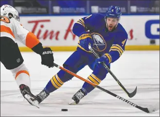  ?? AP PHOTO ADRIAN KRAUS, FILE) ?? Buffalo Sabres left wing Taylor Hall (4) passes the puck while pressured by Philadelph­ia Flyers center Joel Farabee, left, during the second period of an NHL hockey game in Buffalo, N.Y., in this Monday, March 29, file photo. The banged-up Boston Bruins are getting a boost for their late-season playoff push by acquiring forward Taylor Hall in a trade with the Buffalo Sabres reached early Monday.