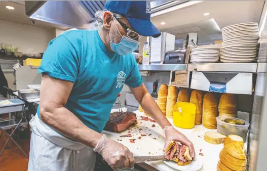  ?? PHOTOS: DAVE SIDAWAY ?? “What makes this place tick is there are no owners standing around in ties here and telling us what to do. They’re workers,” says Snowdon Deli smoked-meat cutter Bobby Hliaras.