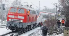  ?? FOTO: DPA/BENJAMIN LISS ?? Eine rote Diesellok schleppte am Sonntag den in Hergatz liegengebl­iebenen Elektro-Zug ab.