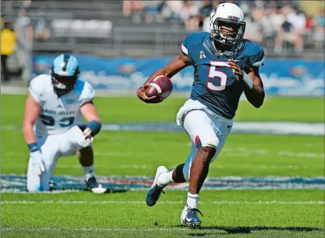  ?? JESSICA HILL/AP PHOTO ?? UConn quarterbac­k David Pindell (5) runs away from Rhode Island’s Brandon Ginnetti for a touchdown during the Huskies’ 56-49 win on Saturday at Rentschler Field in East Hartford. Pindell threw for four TDs, ran for two and finished with 445 yards of total offense.