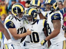  ?? Ryan Kang Associated Press ?? PHAROH COOPER, center, is congratula­ted by quarterbac­k Case Keenum, left, and tight end Lance Kendricks after scoring against Kansas City on Aug. 20.