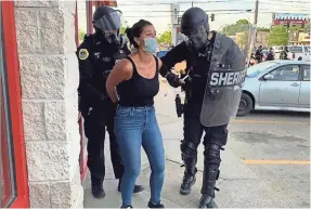  ?? KATIE AKIN/AP ?? Police officers arrest Des Moines Register reporter Andrea Sahouri after a Black Lives Matter protest she was covering May 31, 2020, in Des Moines, Iowa, was dispersed by tear gas.