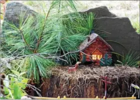  ??  ?? A fairy home in a wooded setting, a piece of slate used as the backdrop.