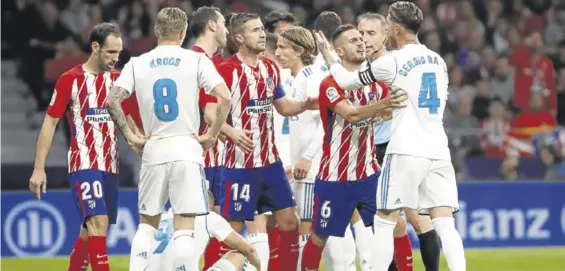  ??  ?? Jugadores de ambos equipos discuten con Benzema en el suelo.