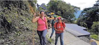  ?? MAYELA LÓPEZ ?? Marjorie Aguilar, vecina de La Estrella de El Guarco, pasó por un tramo de la carretera que se cayó cerca del kilómetro 36 para llegar hasta San Cristóbal Norte a dejarle unas pastillas a su esposo.