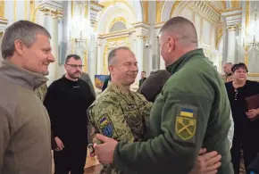  ?? UKRAINIAN PRESIDENTI­AL PRESS OFFICE VIA AP ?? Oleksandr Syrskyi, left, newly appointed commander-in-chief of Ukraine’s armed forces, and outgoing commander Valerii Zaluzhnyi embrace at a ceremony Friday in Kyiv, Ukraine.