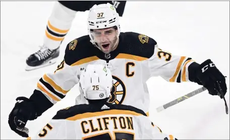  ?? GRAHAM HUGHES — THE CANADIAN PRESS VIA AP ?? Boston captain Patrice Bergeron celebrates with teammate Connor Clifton after scoring against the Montreal Canadiens during the third period. Bergeron’s goal lifted the Bruins to a 4-2 win in Montreal.