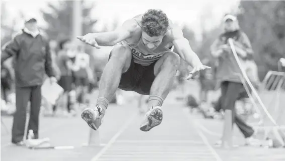  ??  ?? Oak Bay High’s Valdi Alarie flies through the air during a triple jump at the Island high school track and field championsh­ips Wednesday at Centennial Stadium.