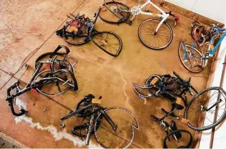  ?? Associated Press photos ?? Mangled bicycles are tagged as evidence at the Michigan State Police crime lab in Kalamazoo. A pickup driver hit a group of nine cyclists in June 2016 near Kalamazoo, killing five of them.