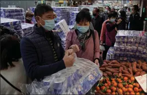  ?? (AP/Kin Cheung) ?? Customers wear face masks Saturday as they shop at a store in Hong Kong. More photos at arkansason­line.com/29virus/