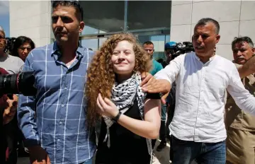  ??  ?? Tamimi (centre) arrives at the mausoleum of former Palestinia­n leader Yasser Arafat in Ramallah in the occupied West Bank after she was released from prison earlier in the day following an eight-month sentence for slapping two Israeli soldiers. — AFP...