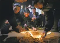  ?? ARIEL SCHALIT AP ?? Israelis light candles Saturday in memory of seven Israelis killed Friday by a Palestinia­n gunman in east Jerusalem.