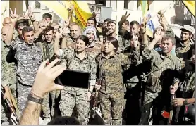  ?? AP/Hawar News Agency ?? This frame grab from video released Tuesday and provided by Hawar News Agency, a Syrian Kurdish activist-run media group, shows fighters from the U.S.-backed Syrian Democratic Forces celebratin­g in Raqqa, Syria.