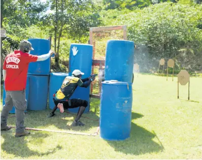  ?? PHOTOS BY JANET SILVERA ?? A shooter competes in the recent fundraisin­g shooting competitio­n, while a ranger officiates at the Negril Tactical Shooting Range.