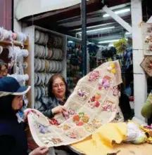  ??  ?? Women doing handy work in Paseo Rosas, one of the city’s oldest streets where lace and buttons are sold