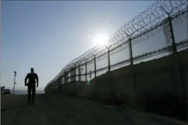  ?? GREGORY BULL — THE ASSOCIATED PRESS FILE ?? FILE—In this file photo, a Border Patrol agent walks along a border structure in San Diego The U.S. Border Patrol’s parent agency may exempt many veterans and law enforcemen­t officers from a requiremen­t that new hires take a lie-detector test.