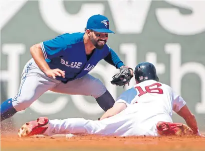  ?? ELISE AMENDOLA/THE ASSOCIATED PRESS ?? Jays second baseman Devon Travis tags out Boston’s Andrew Benintendi trying to steal second during third-inning play at Fenway.