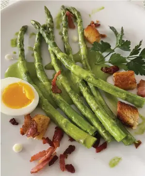  ?? PHOTO BY CATHY THOMAS ?? Asparagus is served with bacon croutons and a soft-boiled egg.