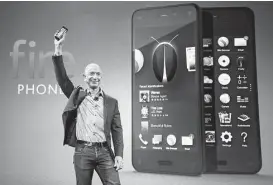  ?? Ted S. Warren / Associated Press ?? Amazon CEO Jeff Bezos introduces the Amazon Fire smartphone at a Wednesday event in Seattle. The goal is not to dominate cellphones but to add shoppers.