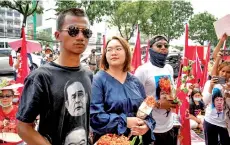  ?? — AFP photo ?? (From left) Panupong, Panusaya and Jatupat hold flowers given by supporters outside the Office of the Attorney General, as they arrive to be indicted on charges of violating Thailand’s royal defamation law, in Bangkok.