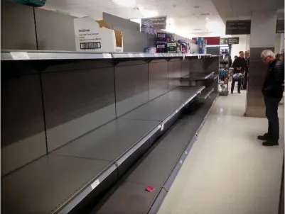  ??  ?? Cleared out: Shelves emptied of toilet paper at Waitrose in Saffron Walden, Essex, yesterday