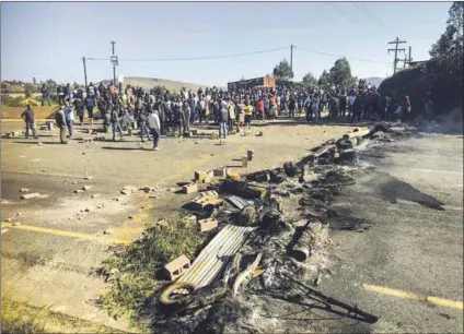  ?? Photos: Nompendulo Ngubane/ groundup ?? Fed up: In Pietermari­tzburg, protesters in Henley Village (above) and Ezinkethen­i (left) protest over the poor water supply and residents in Bhakabha Road (below) over potholes in the street.