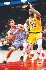  ?? AP PHOTO/JOHN BAZEMORE ?? Atlanta guard Trae Young drives against Los Angeles Lakers forward LeBron James during the first half of Tuesday’s game in Atlanta.