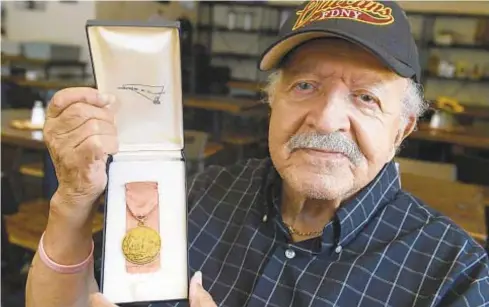  ?? TODD MAISEL/NEW YORK DAILY NEWS ?? Retired Firefighte­r James Tempro, 91, holds FDNY’s top honor, the James Gordon Bennett Award, which Mayor John Lindsay presented him with in 1969 (below) for saving a boy’s life. The FDNY has since come to grips with Bennett’s racist history and is taking his name off the honor.