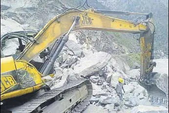  ?? HT PHOTO ?? A JCB machine clears Badrinath highway roadblock at Hathi Parvat landslide zone in Chamoli district on Saturday.