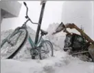  ?? CHARLES KRUPA, THE ASSOCIATED PRESS ?? A loader dumps snow onto a pile in Boston.