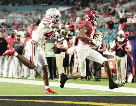  ?? AL DIAZ adiaz@miamiheral­d.com ?? Heisman Trophy winner DeVonta Smith scores for Alabama on one of his three touchdown receptions from Mac Jones in the first half as Ohio State’s Josh Proctor gives chase.