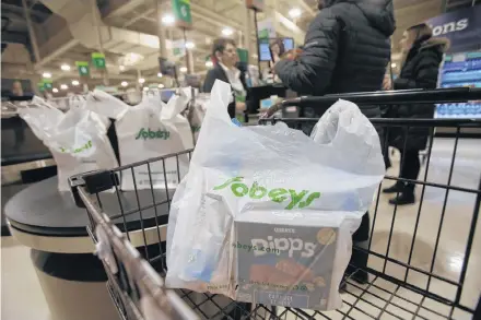  ?? TIM KROCHAK/ THE CHRONICLE HERALD ?? Groceries packed in a plastic bag wait in a shopping cart at a Sobeys in the province.