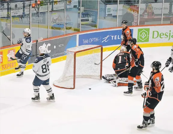  ??  ?? L'attaquant de l'Océanic, Anthony Deluca ( à gauche ), célèbre son premier but de la rencontre après avoir poussé une rondelle laissée libre devant le gardien des Huskies, Samuel Harvey.