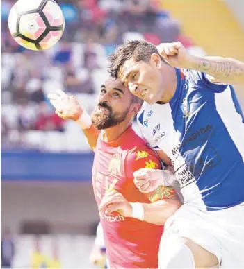  ??  ?? ► Sebastián Jaime y Bruno Romo disputan un balón aéreo.