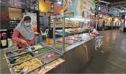  ?? — Chan BOON KAI/ the Star ?? Awaiting recovery: Economy rice seller Susilawati goyo, 48, at her stall at Fisherman’s Wharf Food Corner Penang in george town. Countries with stimulus packages recover better than countries without or limited stimulus packages, according to experts.