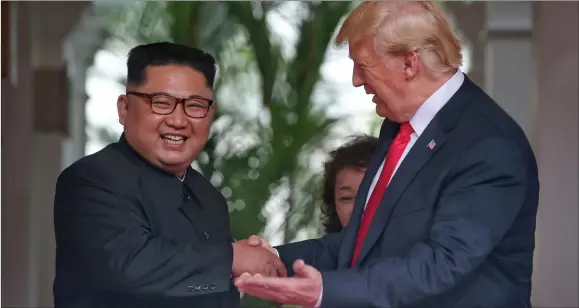  ??  ?? „ North Korean leader Kim Jong-un and US President Donald Trump during their upbeat exchange after signing the historic agreement.