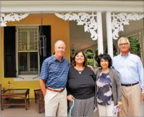  ??  ?? Wayne resident Mojdeh Keykhah (center, right) and her friends, Greg and Elise Haines and Peter Trentacost­e, admire the wrap-around porch of a secluded home in Devon.