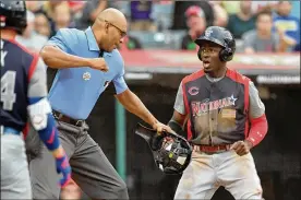  ?? JASON MILLER/GETTY IMAGES ?? Home plate umpire Jose Navas punches out Reds prospect Taylor Trammell of the National League after he tried to steal home during the fourth inning against the American League team during the All-Stars Futures Game at Progressiv­e Field on Sunday night in Cleveland. The American and National League teams tied 2-2. TV replays appeared to show Trammell slipped his hand under catcher Jake Rogers’ tag, and under normal circumstan­ces the play would have likely been reviewed and overturned. “I can say I’m safe all day and he missed the call, but what matters is what’s on the scoresheet,” Trammell said. “It said I was caught stealing.”