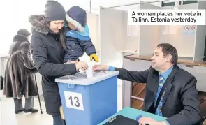  ??  ?? A woman places her vote in Tallinn, Estonia yesterday