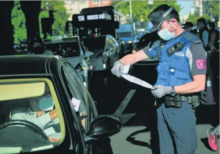  ?? EFE ?? Un agente comprueba el justifican­te de un conductor en un control en Madrid durante el estado de alarma